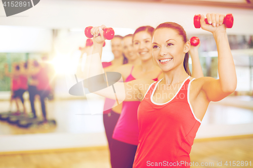 Image of group of smiling people working out with dumbbells