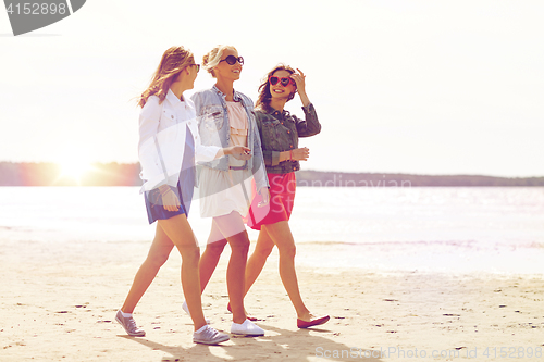 Image of group of smiling women in sunglasses on beach
