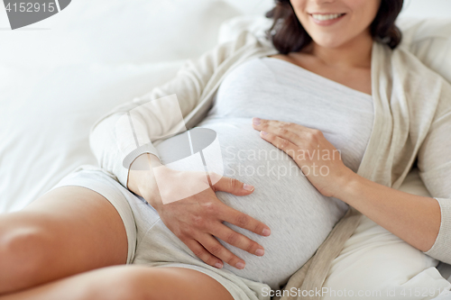 Image of close up of happy pregnant woman in bed at home
