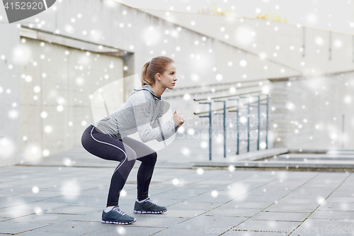 Image of woman doing squats and exercising outdoors