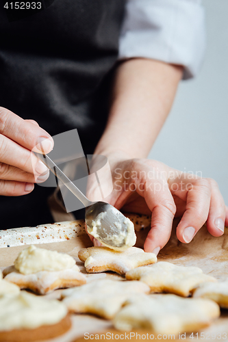 Image of Person putting a cream to the cookies