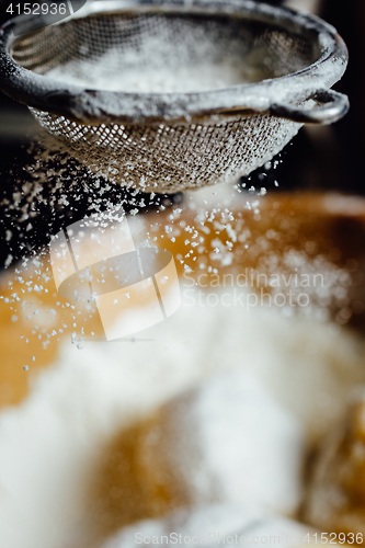 Image of Person covering pastry with flour