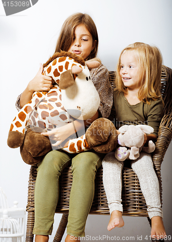 Image of two cute sisters at home interior playing, little happy smiling