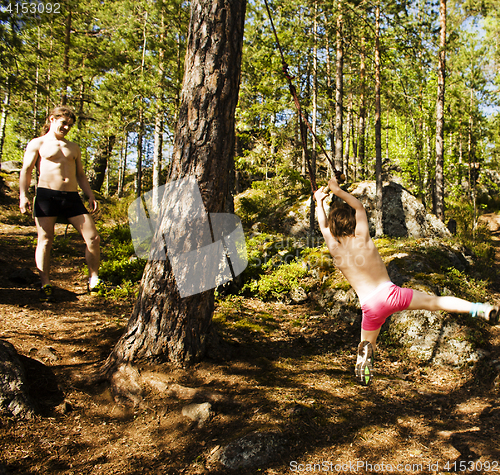 Image of little cute boy jumping with bungee in forest, training with dad