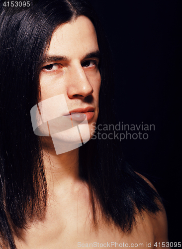 Image of handsome young man with long hair naked torso on black backgroun