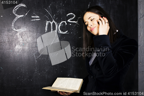 Image of portrait of happy cute student in classroom at blackboard back t