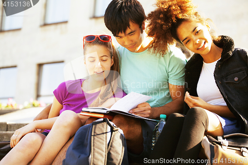 Image of cute group of teenages at the building of university with books 