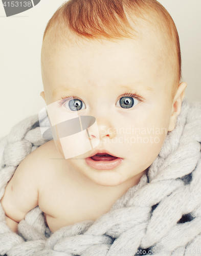 Image of little cute red head baby in scarf all over him close up isolate