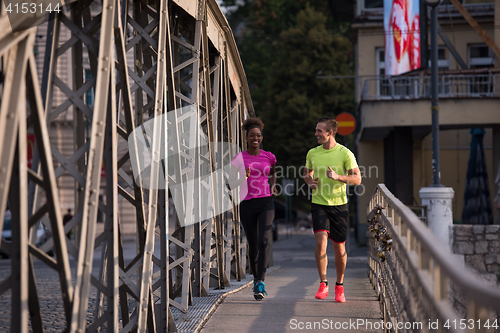 Image of multiethnic couple jogging in the city