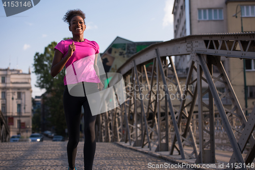 Image of african american woman running across the bridge