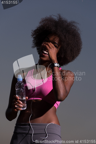 Image of african american woman jogging in nature