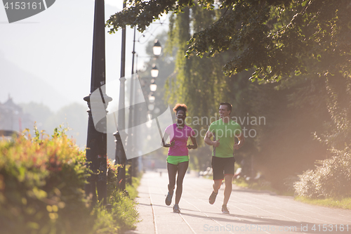 Image of young multiethnic couple jogging in the city