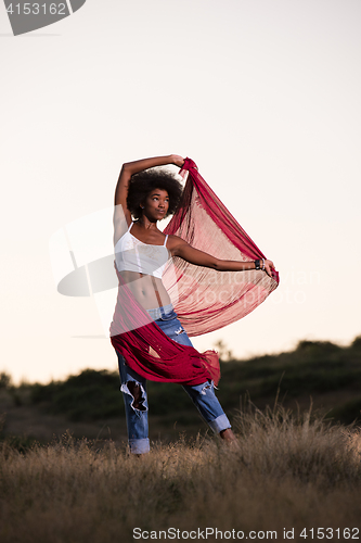 Image of black girl dances outdoors in a meadow