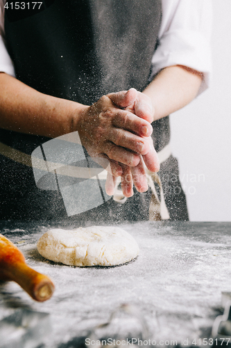 Image of Person beating up dough with flour