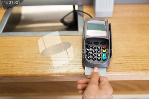 Image of close up of hand inserting bank card to terminal