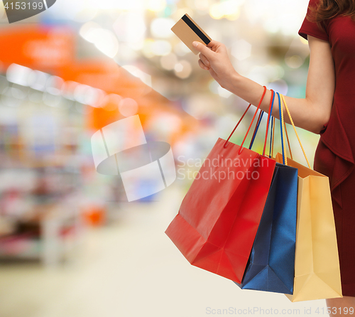 Image of woman with shopping bags and credit card at store