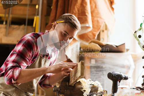 Image of carpenter working with wood plank at workshop