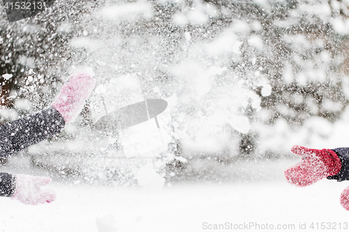 Image of happy friends playing with snow in winter