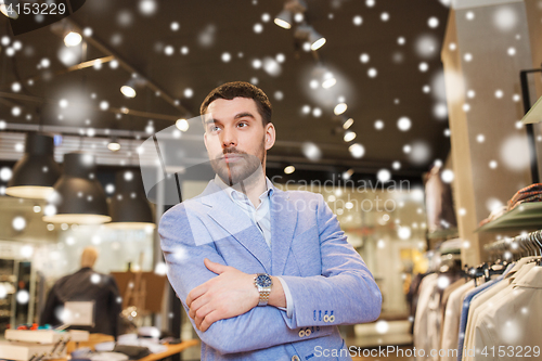 Image of happy young man in jacket at clothing store