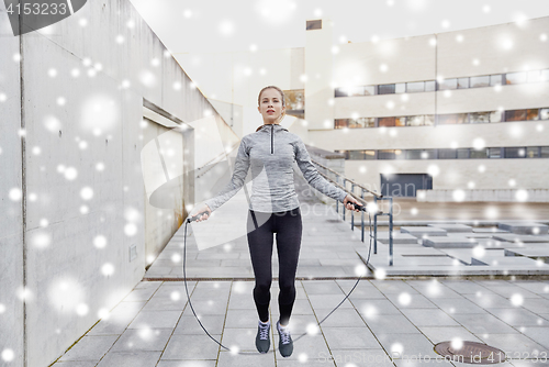 Image of woman exercising with jump-rope outdoors