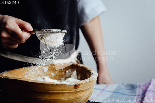 Image of Person covering pastry with flour