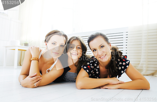 Image of Mature sisters twins at home with little daughter, happy family 