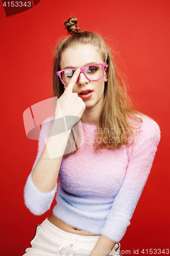 Image of young pretty emitonal posing teenage girl on bright red background, happy smiling lifestyle people concept
