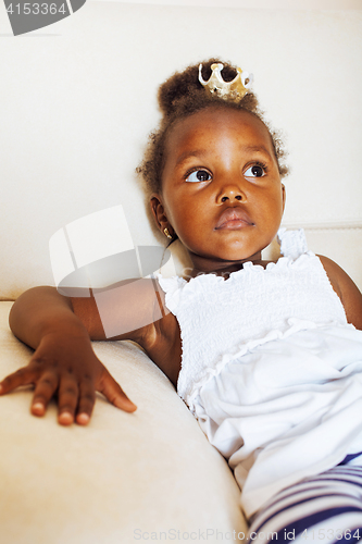 Image of little pretty african american girl sitting in white chair weari