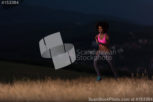 Image of Young African american woman jogging in nature