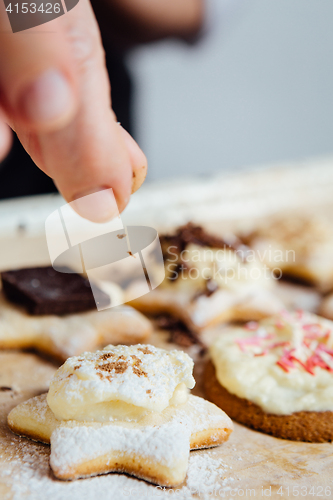 Image of Person adds cinnamon on top of cookie