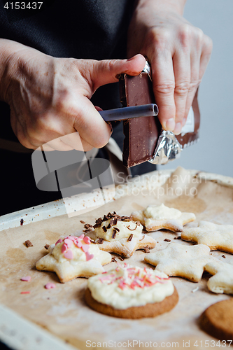 Image of Cook decorating cookies with chocolate