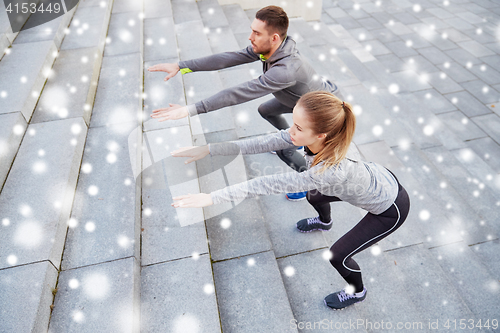 Image of couple of sportsmen doing squats and exercising