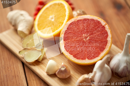 Image of grapefruit, ginger, garlic and orange on board