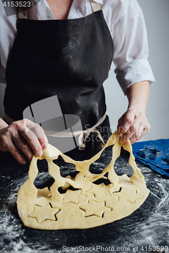 Image of Cook cut out dough for cookies