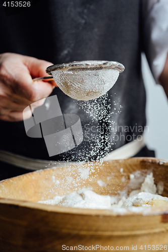 Image of Person covering pastry with flour