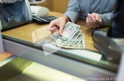 Image of clerk counting cash money at bank office