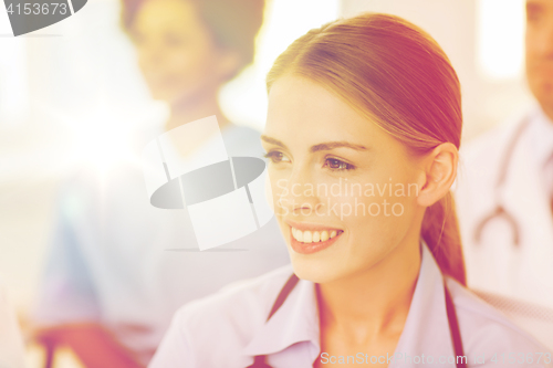 Image of happy doctor over group of medics at hospital