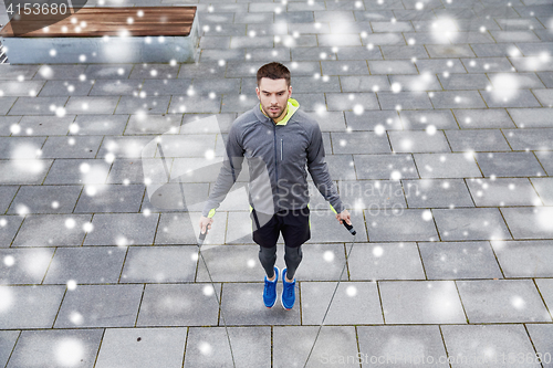 Image of man exercising with jump-rope outdoors