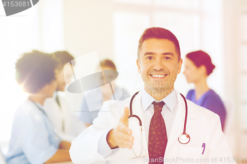 Image of happy doctor over group of medics at hospital