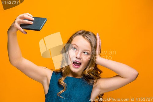 Image of The face of playful happy teen girl with phone