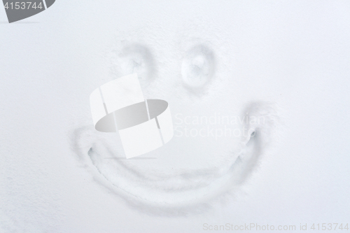 Image of smiley drawing on snow surface