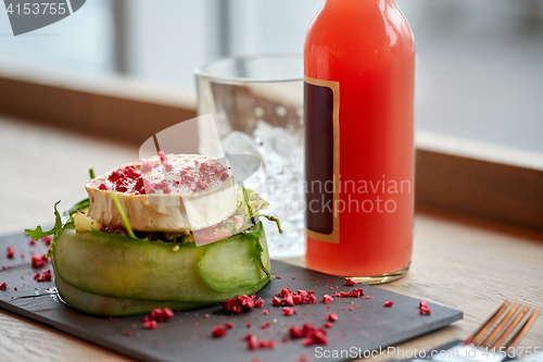 Image of salad, bottle of drink and glass on cafe table