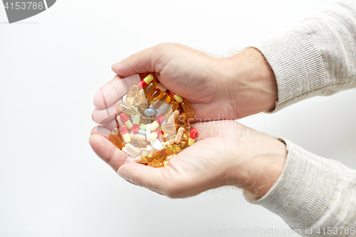 Image of close up of old man hands holding medicine