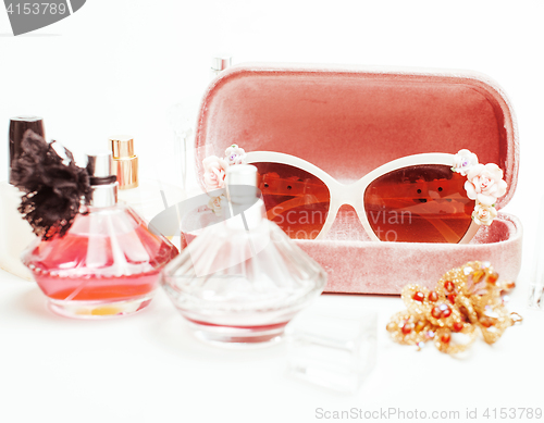 Image of Jewelry table with lot of girl stuff on it, little mess in cosmetic brushes, women interior concept, perfume elegance things