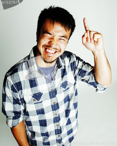 Image of young cute asian man on white background gesturing emotional, pointing, smiling, lifestyle people concept