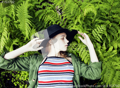 Image of Pretty young blond girl hipster in hat among fern, vacation in green forest