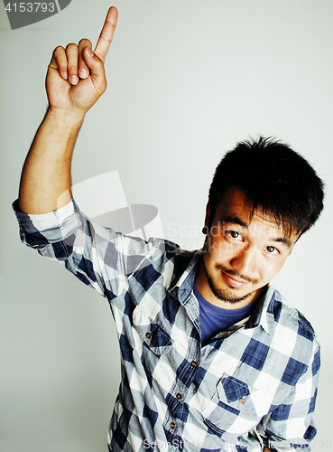 Image of young cute asian man on white background gesturing emotional, pointing, smiling, lifestyle people concept