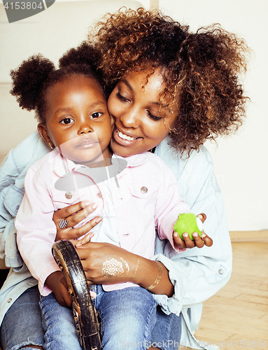 Image of adorable sweet young afro-american mother with cute little daughter, hanging at home, having fun playing smiling, lifestyle people concept