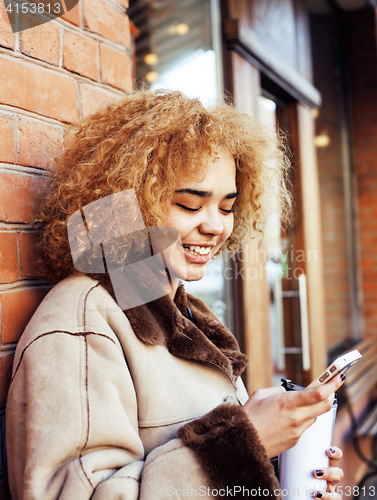 Image of young pretty african american women drinking coffee outside in cafe, modern business woman lifestyle concept