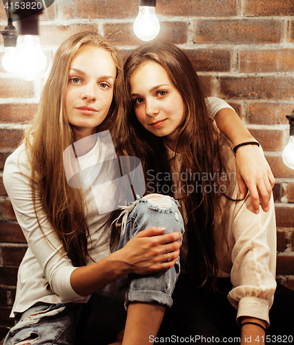 Image of pretty teenage girlfriends having fun in stylish modern loft studio, lifestyle people concept